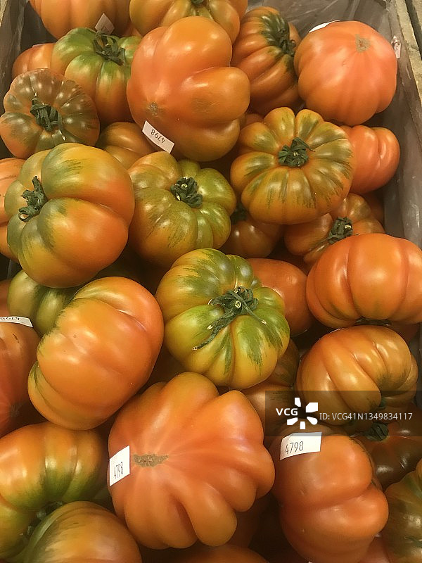 美丽的美食传家宝番茄，一堆红色和绿色的新鲜水果在市场摊位上，有机美味的传统番茄，健康的地中海饮食成分图片素材