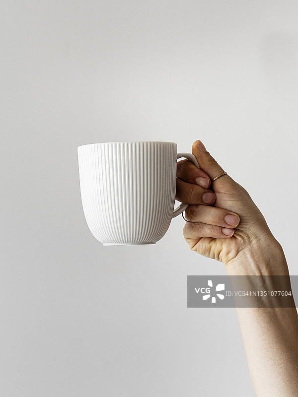 女士的手举起手拿咖啡杯，女士的手拿咖啡杯，新鲜的咖啡杯，手臂举起手拿咖啡杯图片素材