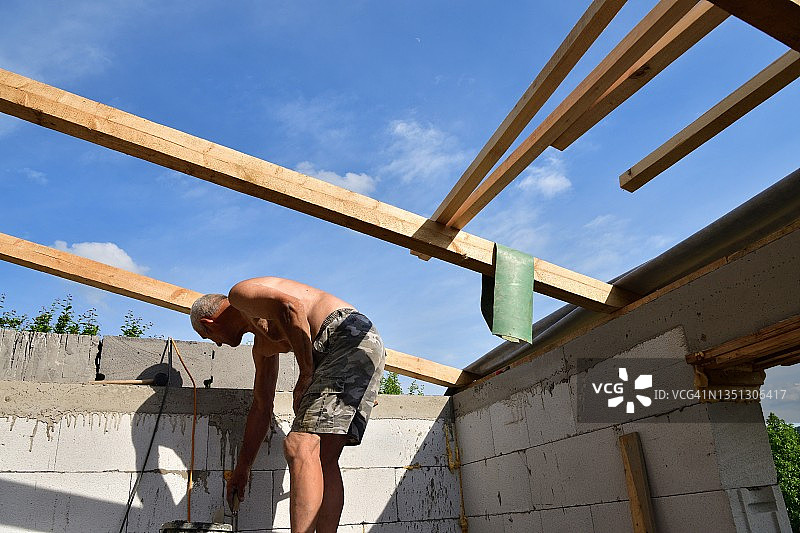 屋顶上的木匠在建筑工地上做木屋顶图片素材