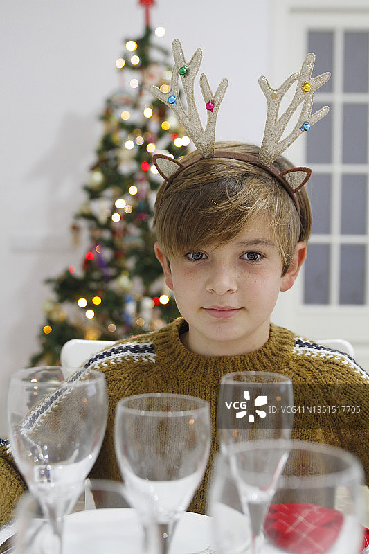 男孩在圣诞节的餐桌上图片素材