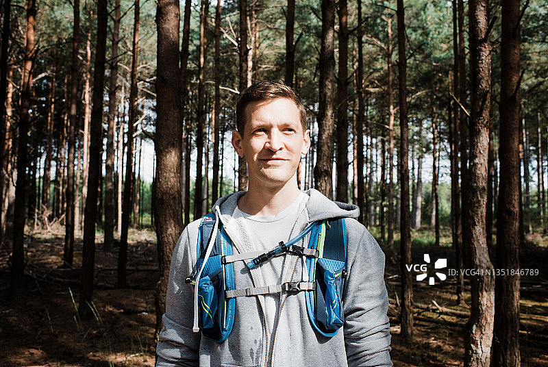 一个男人的肖像站在森林里，穿着跑步背心图片素材