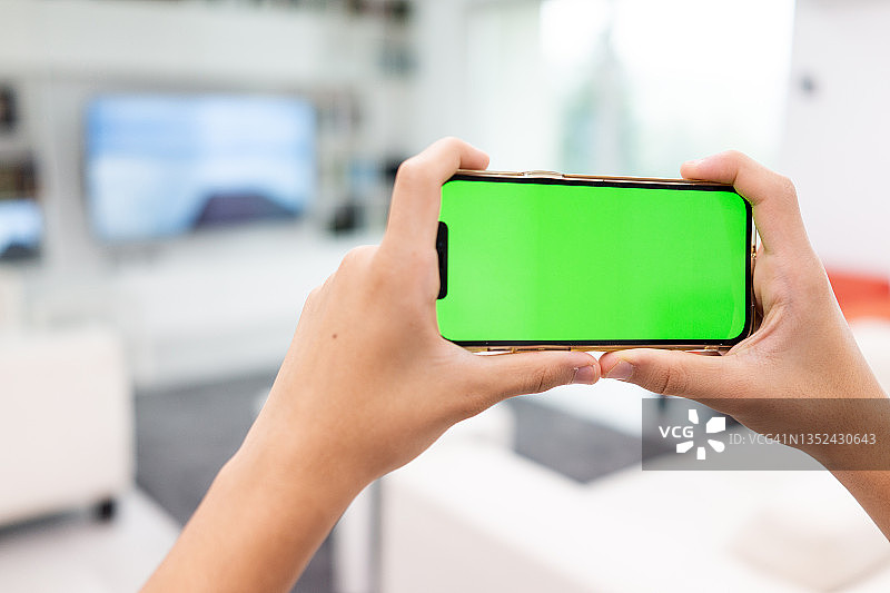 手机绿色屏幕在室内图片素材