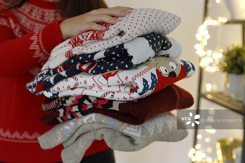 女人拿着一叠叠好的圣诞毛衣图片素材