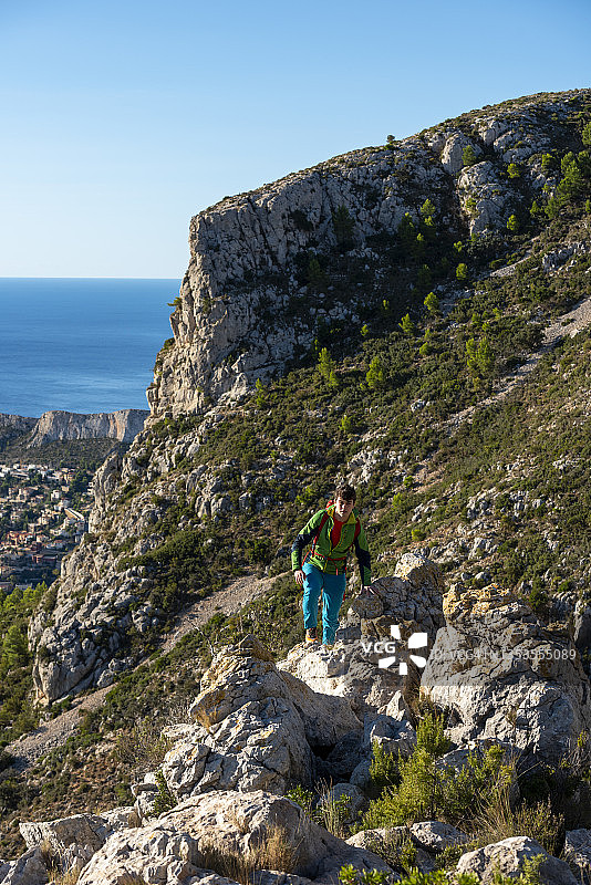 一名年轻人在日出时徒步穿越岩石景观图片素材