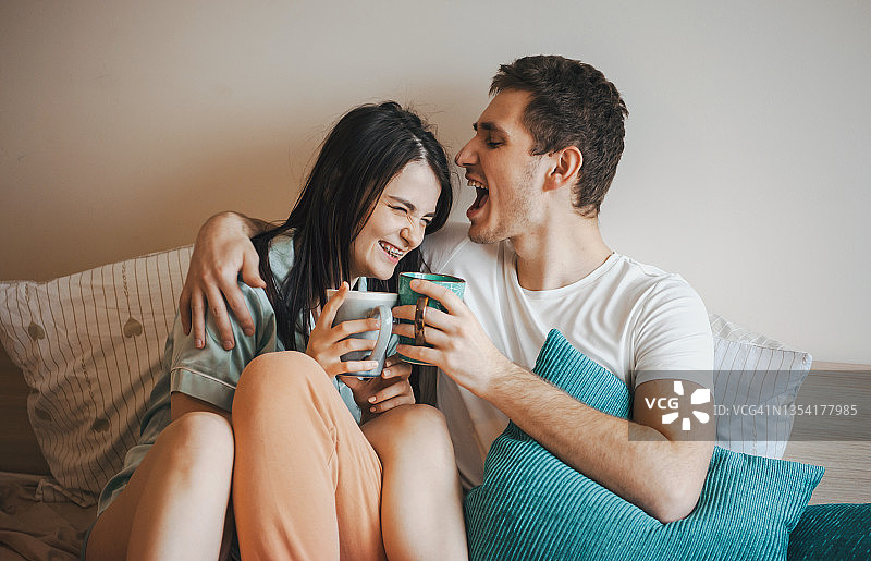 夫妻俩喝着咖啡，拥抱在一起，度过了快乐的时光图片素材