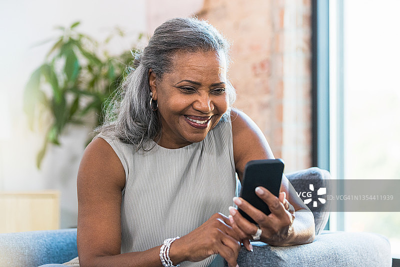 活跃的老年女性使用智能手机图片素材