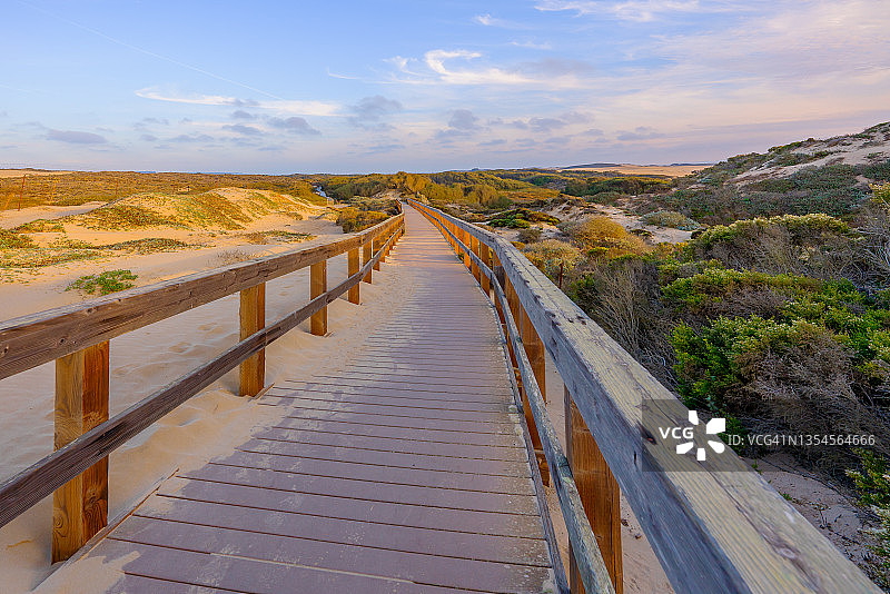 质朴的木质海滩木板路穿过沙丘通向海滩图片素材