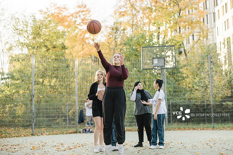 十几岁的女孩在篮球场练习罚球图片素材