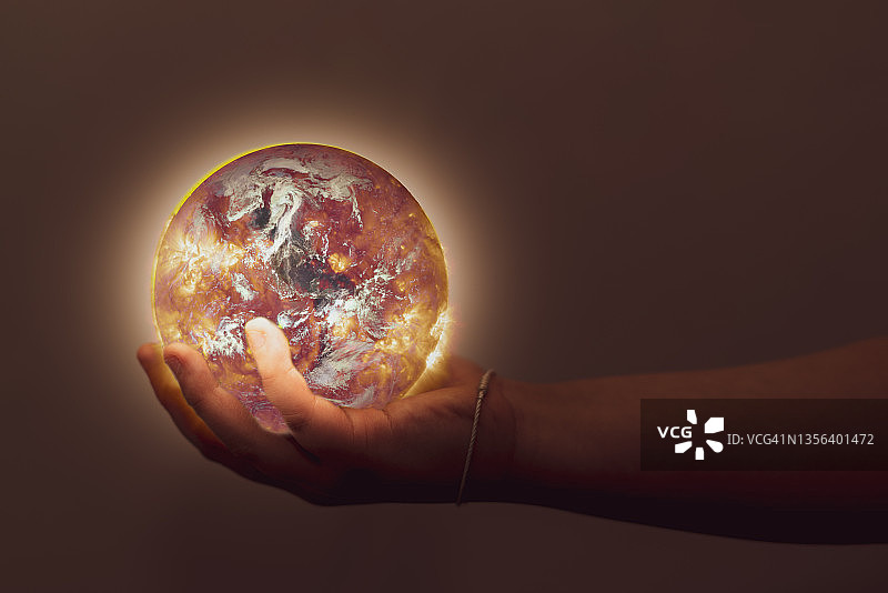 手握世界地球仪，保护生态环境，将蓝色星球从全球变暖中拯救出来图片素材
