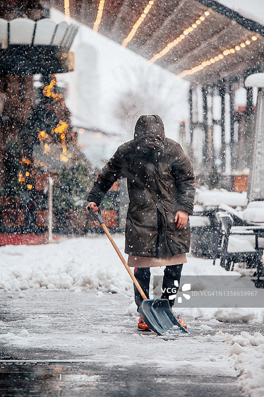 一名男子在暴风雪后铲雪图片素材