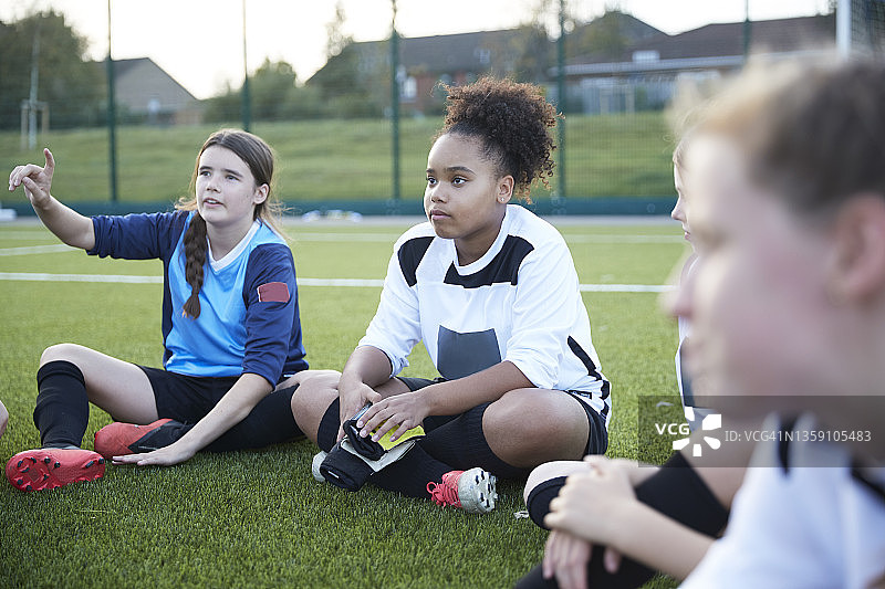 英国，女子足球队在训练期间坐在场地上图片素材