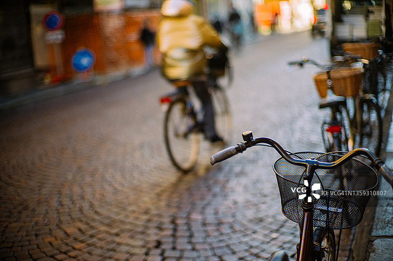 路边停着自行车，后面是骑自行车的人图片素材