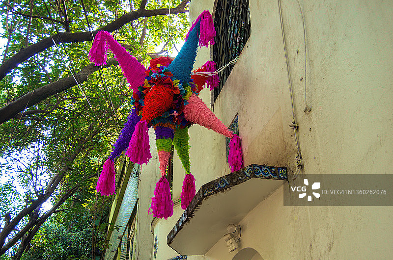 墨西哥圣诞节piñata挂在老房子前图片素材
