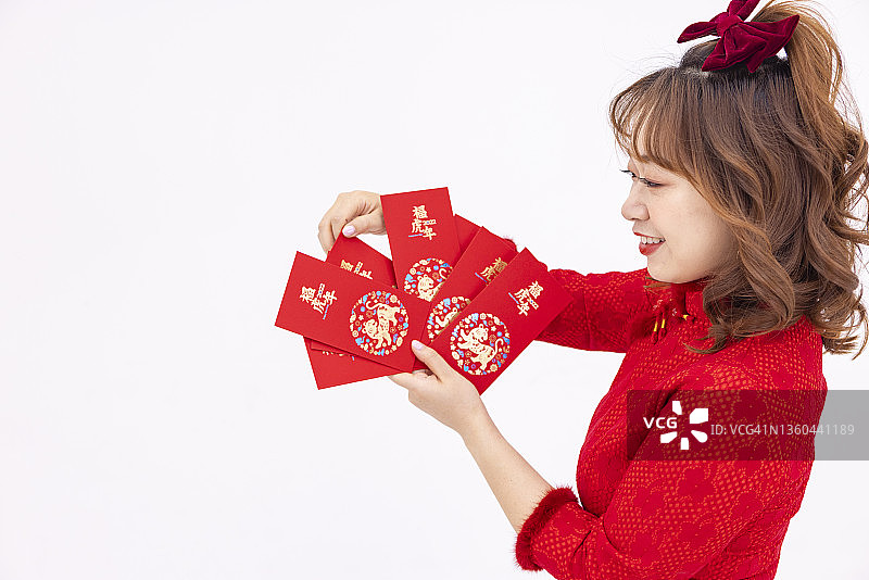 快乐的年轻女子拿着红包庆祝中国新年图片素材