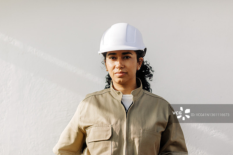 西班牙女电工的肖像在制服和安全帽图片素材