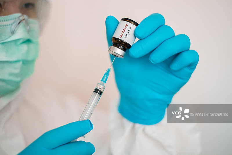 一名医疗工作者正在准备一剂COVID-19疫苗。图片素材