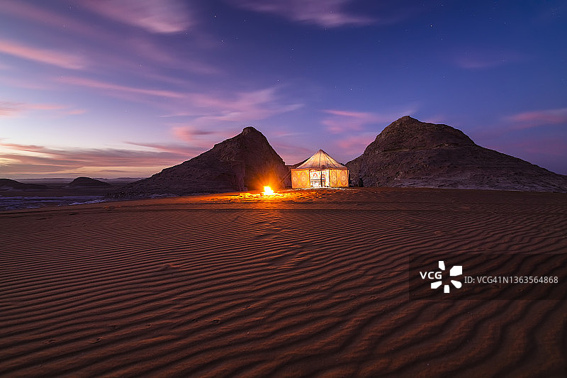 在繁星点点的天空下，在日落时分的白色沙漠中营火。埃及,撒哈拉沙漠图片素材