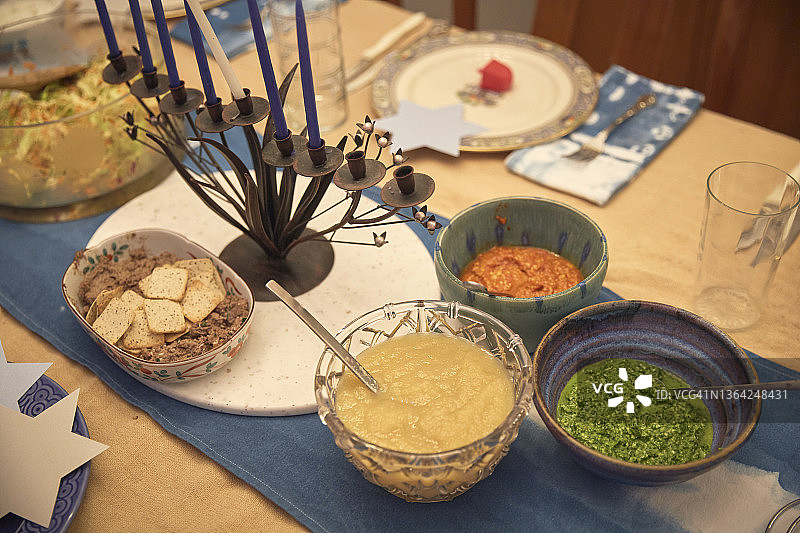 从上方拍摄的一张桌子，上面放着光明节传统的犹太食物，包括鸡肝和苹果酱图片素材