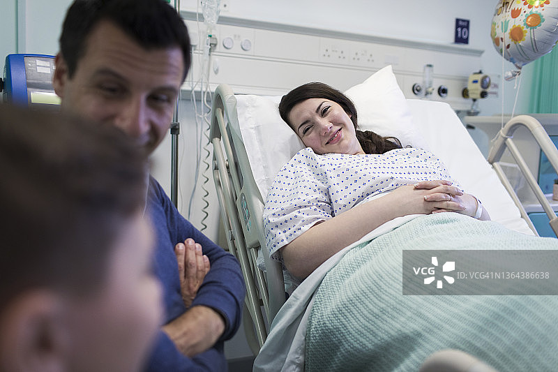 微笑的病人在病房探望家人图片素材
