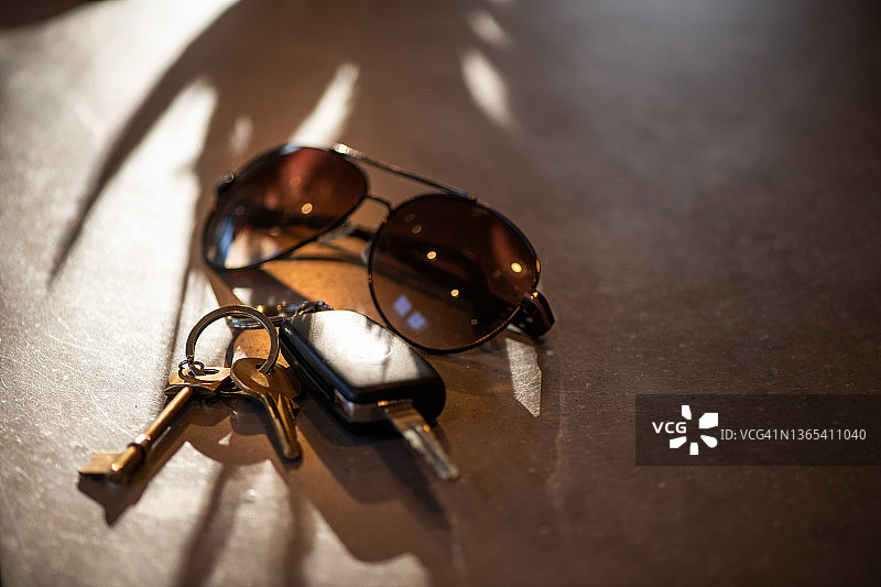 在工作台上放太阳镜、车钥匙和房子钥匙图片素材