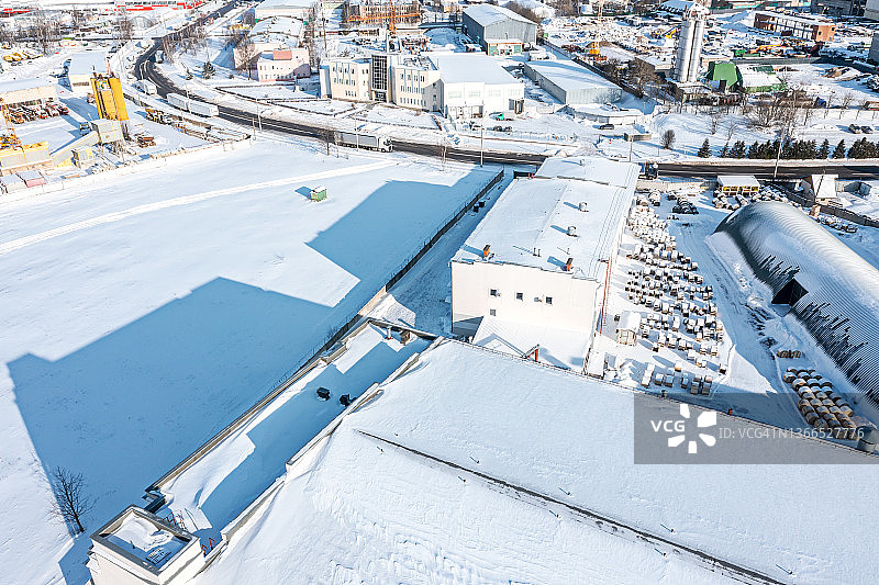 冰雪覆盖的工业区，仓库和制造业建筑。鸟瞰图在冬季阳光明媚的日子。图片素材