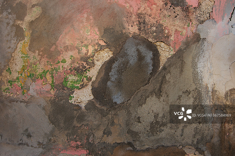 新修复的旧混凝土灰泥墙上的洞，有几层腐蚀和剥落的油漆图片素材
