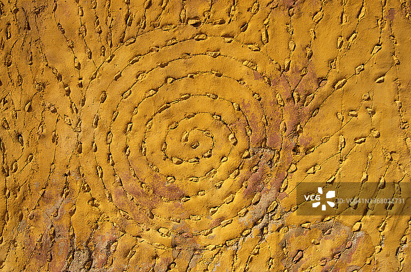 螺旋图案，用蚀刻和石头在灰泥建筑的外墙上制作图片素材