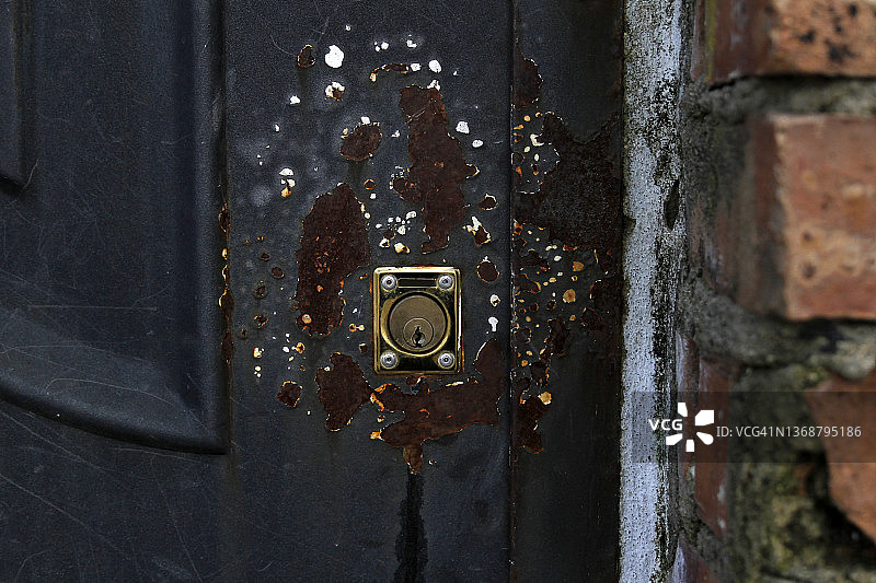 风化门上生锈钥匙孔的特写图片素材