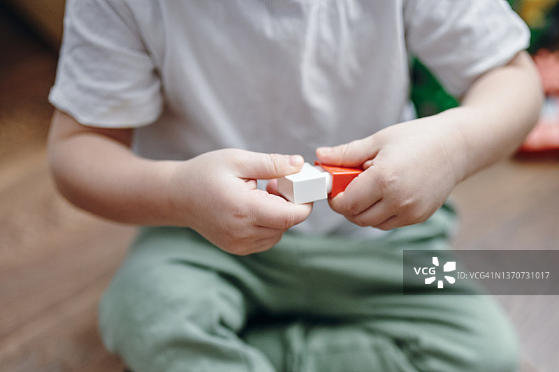 一个三岁的男孩在玩彩色方块。图片素材