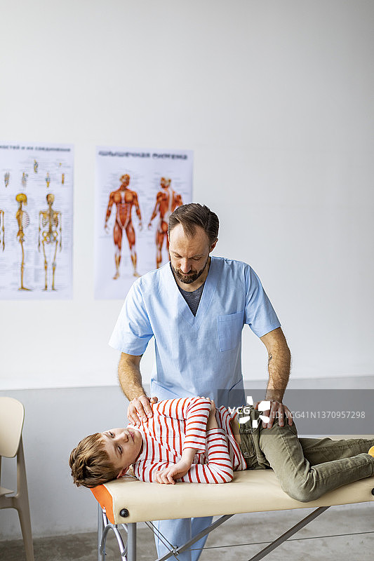 物理治疗师带着孩子在他的诊所里做运动图片素材