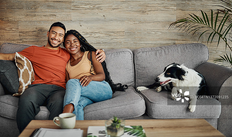 这张照片拍摄的是一对年轻夫妇和他们的博德牧羊犬坐在家里的沙发上图片素材