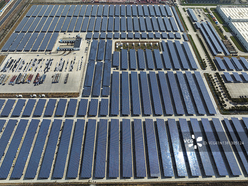 太阳能电池板安装在工厂屋顶和停车场的鸟瞰图图片素材