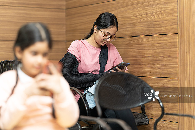印度:坐在诊所候诊室里的少女图片素材