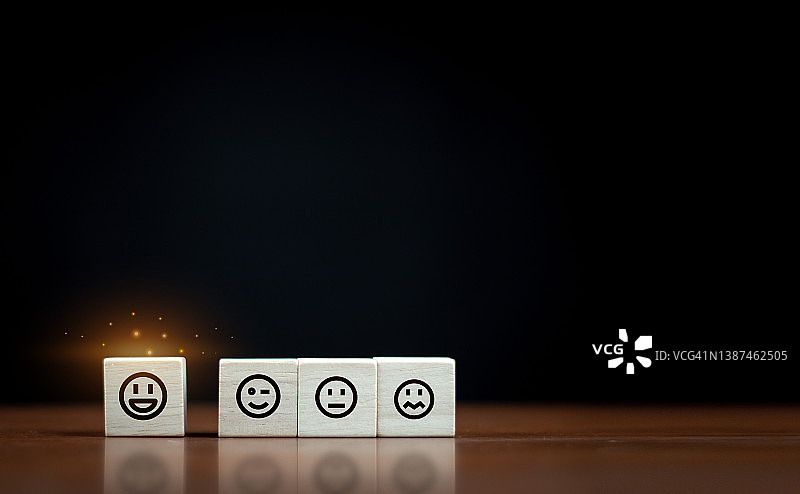 木块上摆以快乐的笑脸符号，评价，提升评级，客户体验，满意度和最佳卓越的服务评级理念。图片素材