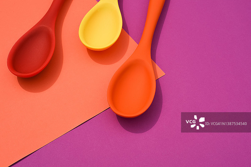 彩色硅胶勺在粉红色的背景。烹饪的背景。烹饪弗拉。美食博客。餐具。图片素材