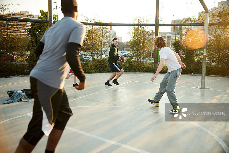 一群朋友在街球训练场打篮球比赛。图片素材