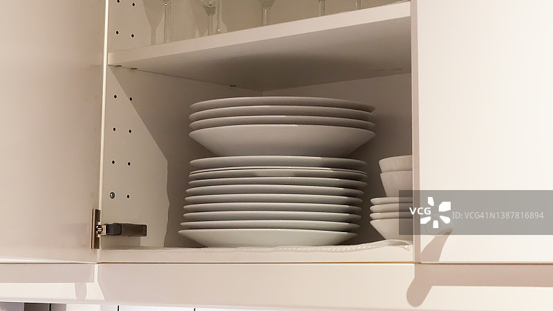 厨房里有白色的橱柜和白色的陶器，各种干净的盘子图片素材