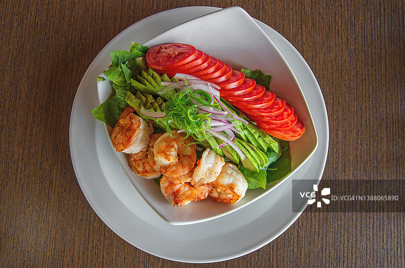 烤虾，鳄梨，西红柿和菠菜沙拉放在碗里图片素材