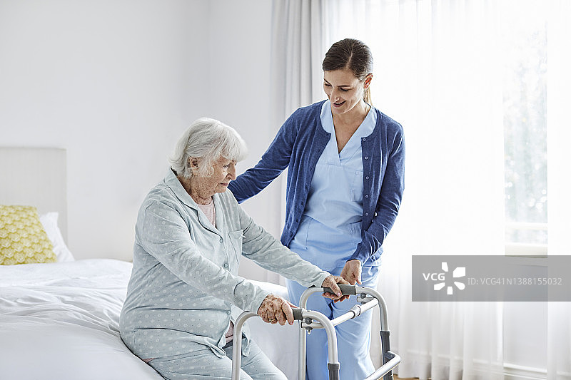 护士支持残疾的老年妇女站起来图片素材