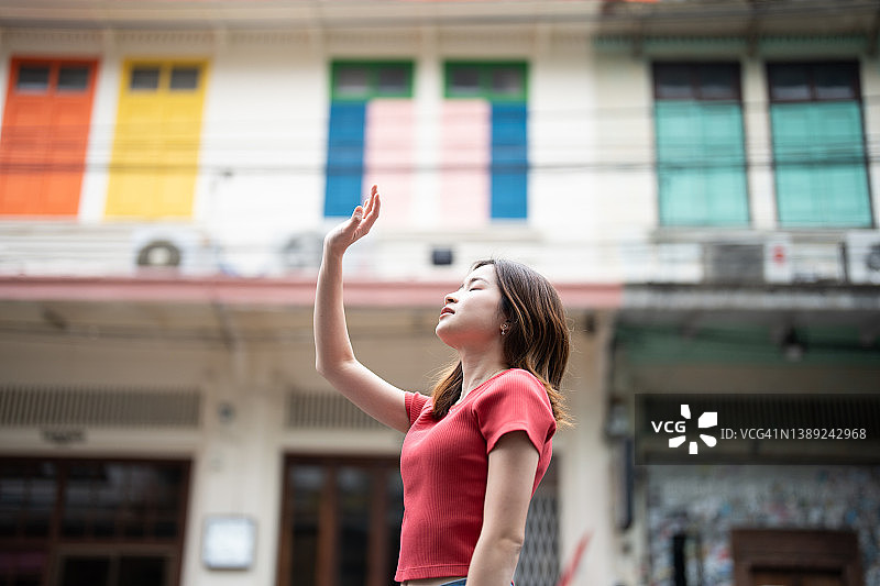 一个女人走在曼谷一条狭窄多彩的小巷上图片素材