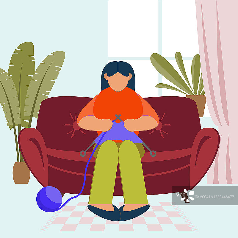 一个女人坐在沙发上，在舒适的室内用针线团织毛衣图片素材