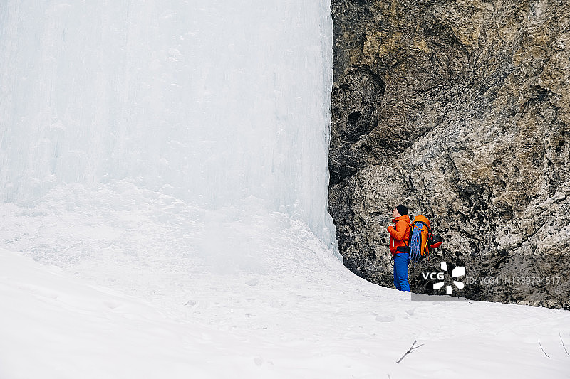 一位男性攀冰者接近班夫附近一个原始冰冻瀑布的底部图片素材