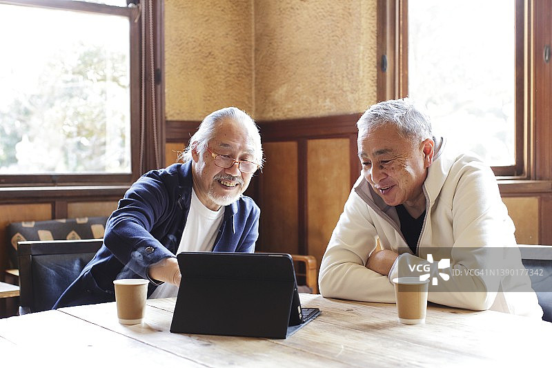 两个年长的男性在用平板电脑图片素材