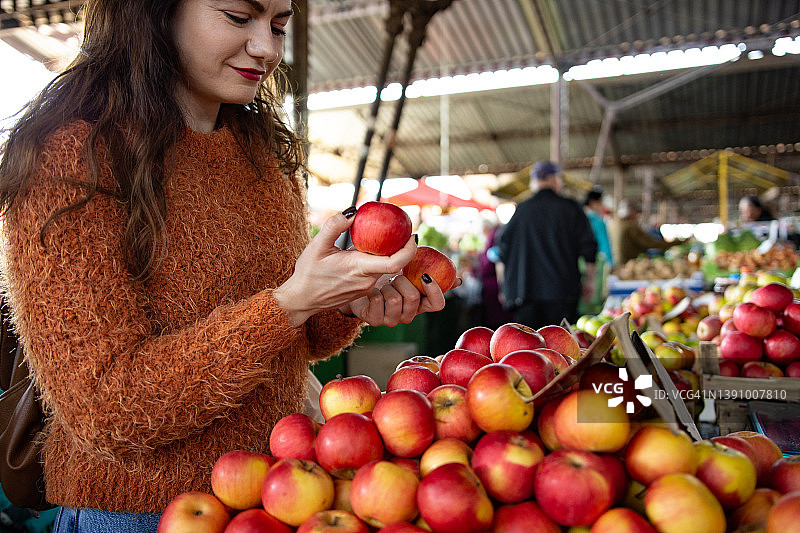 一名年轻女子在当地食品市场购买新鲜水果和蔬菜的照片图片素材
