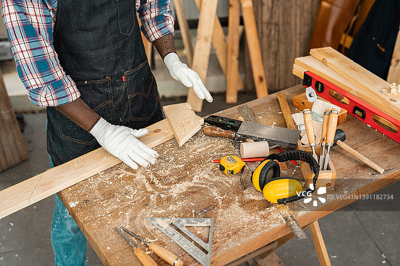 木匠手戴着工作手套，拍去木屑图片素材