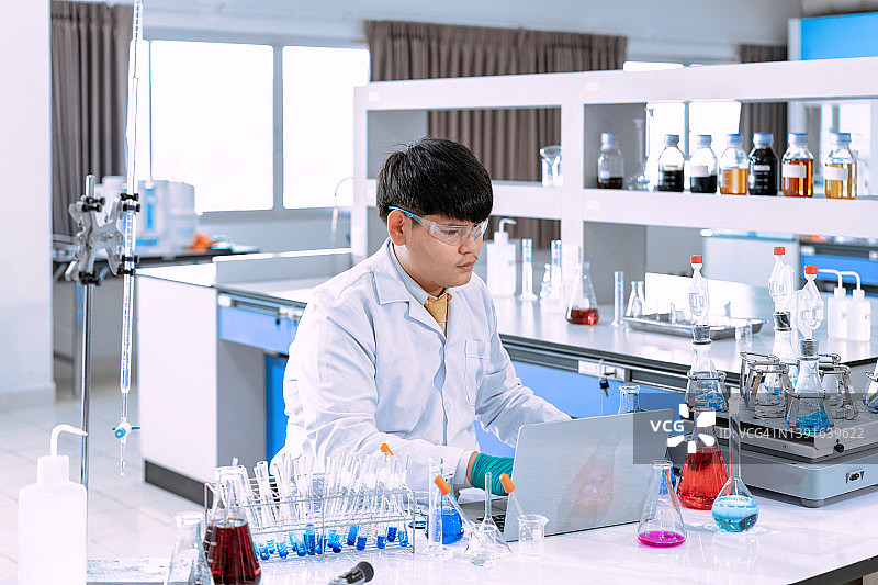 在实验室工作的年轻亚洲男性科学家。医生和科学家在实验室工作的冠状病毒大流行，covid - 19概念图片素材