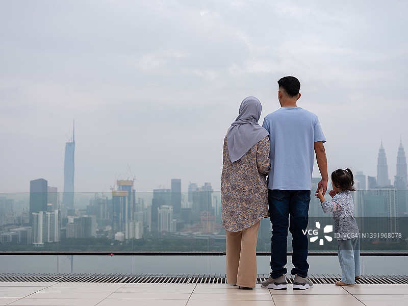 亚洲家庭看着风景优美的城市天际线图片素材