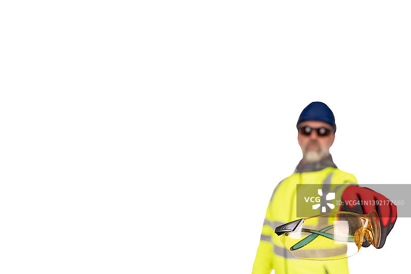 一名建筑工人穿着亮黄色的高维外套，戴着红色的安全手套，给观众戴着有色安全眼镜，以保护眼睛。施工现场安全的旗帜理念图片素材