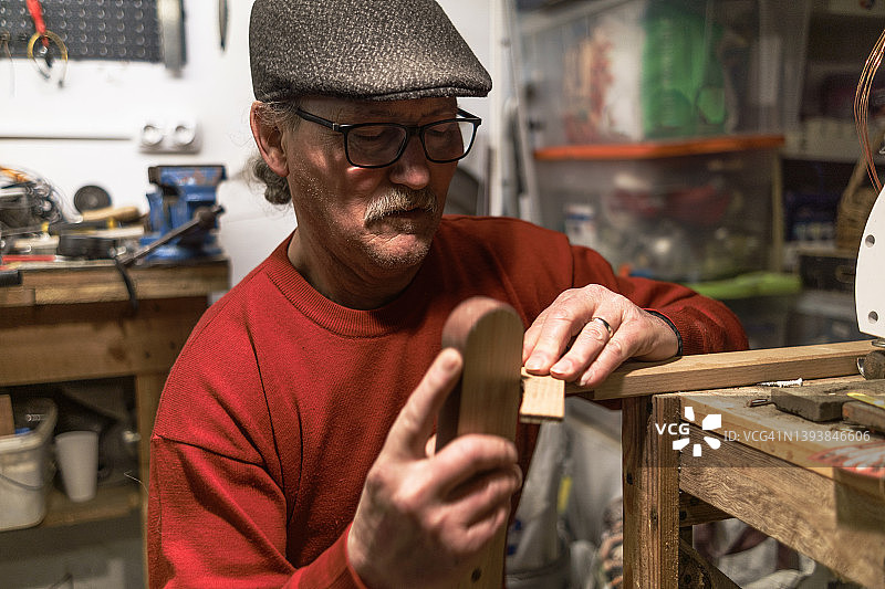 一个退休的人在做一件木制家具图片素材