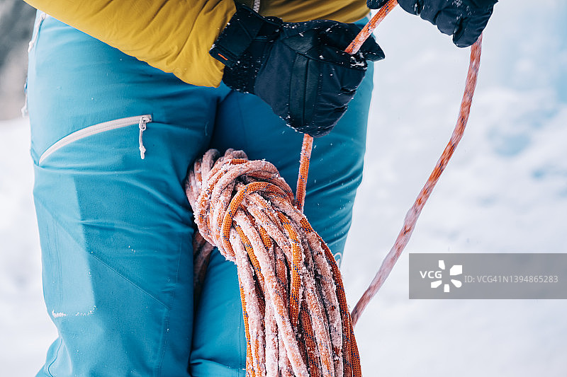 一名登山者在寒冷的天气里在落基山脉中缠绕登山绳的细节镜头图片素材